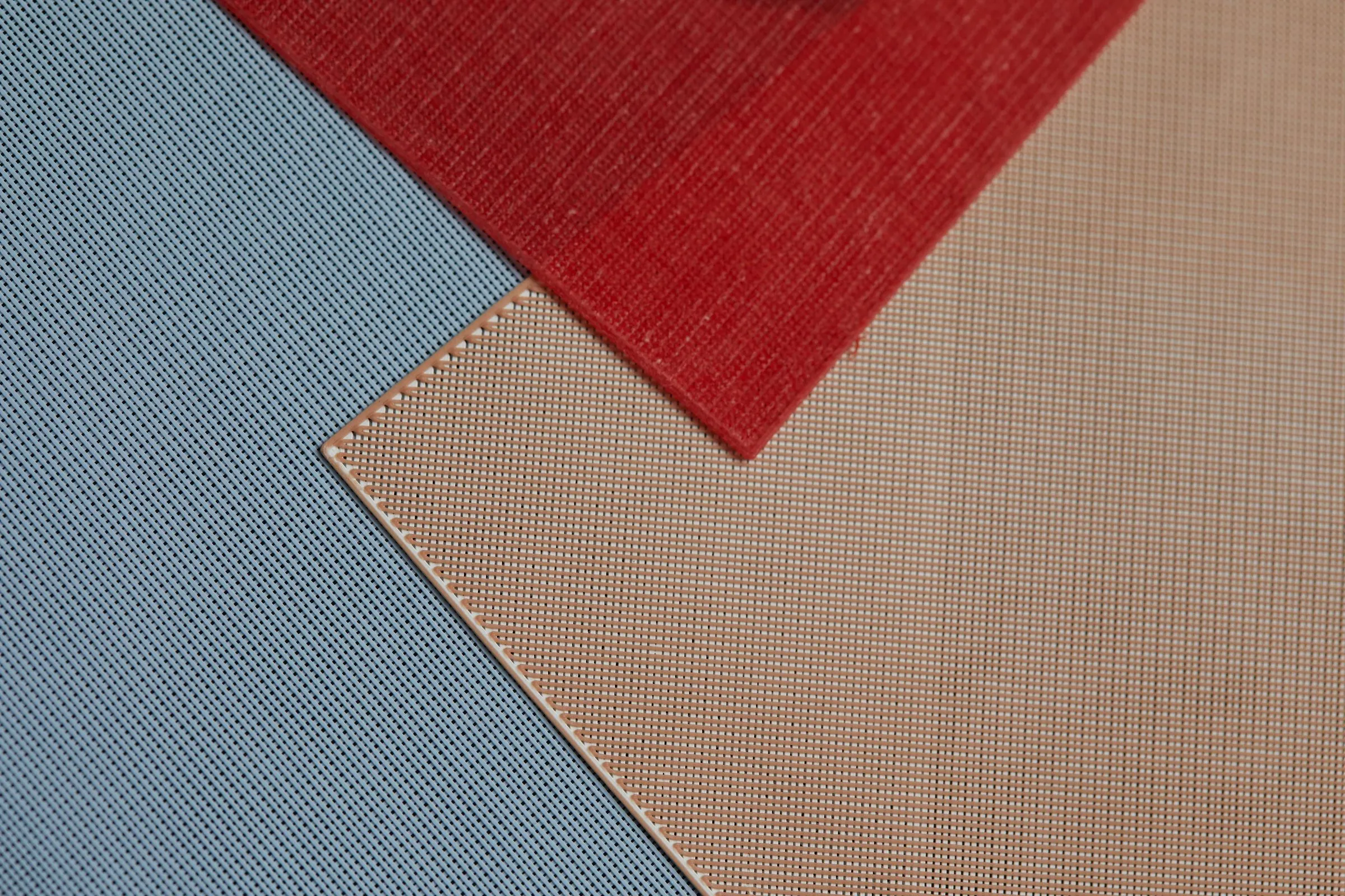 A tan printed panel laid over a blue one, the edge of its weave