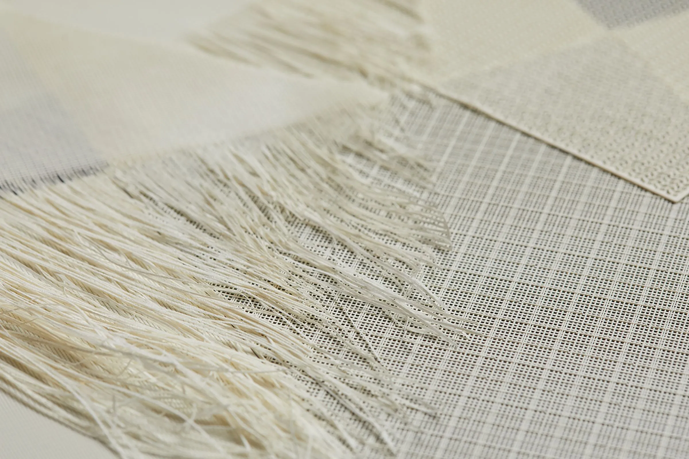 Loose natural fibers fanning out from a printed edge
